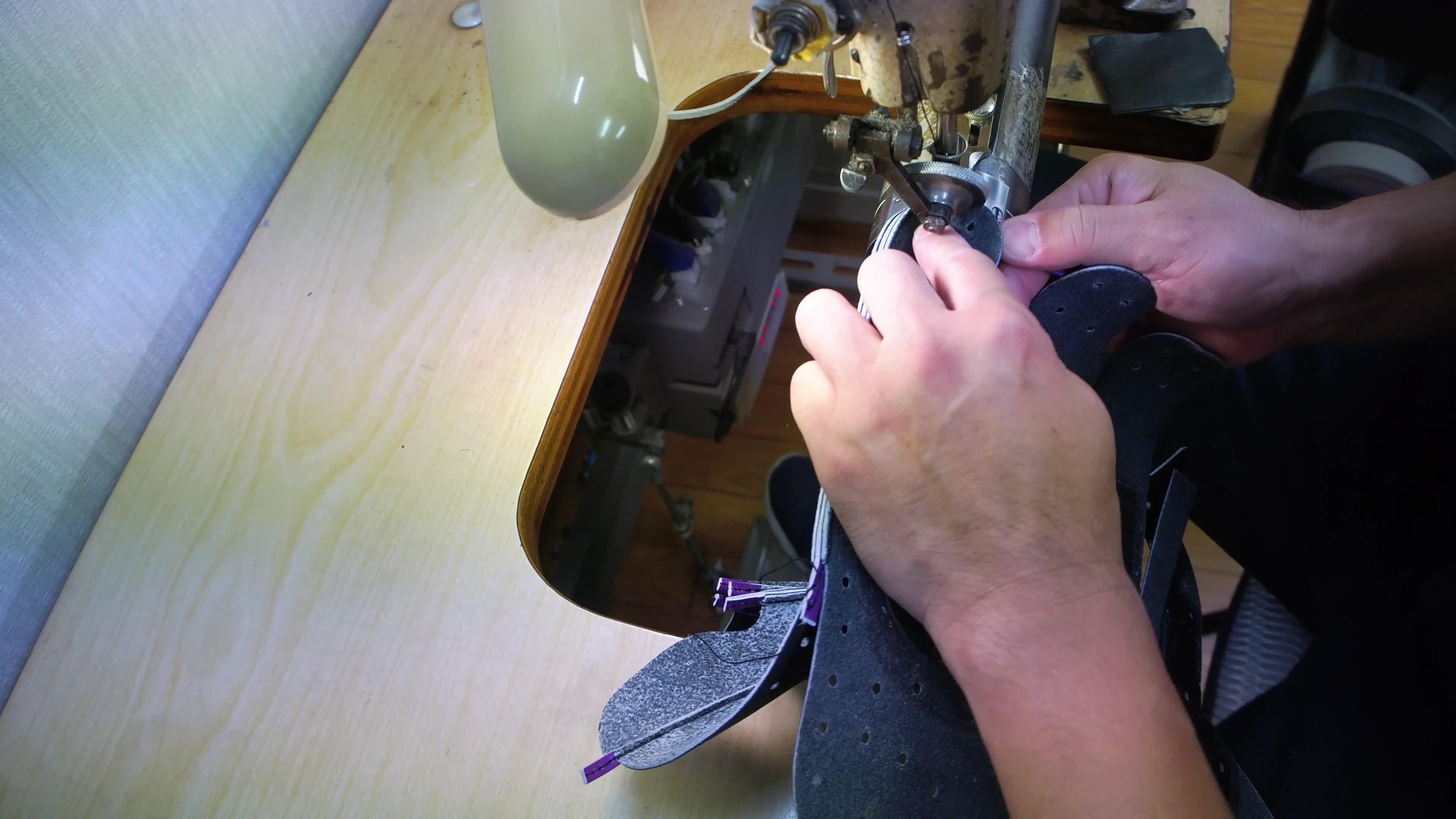An artisan hand-stitching a Ryu baseball glove.